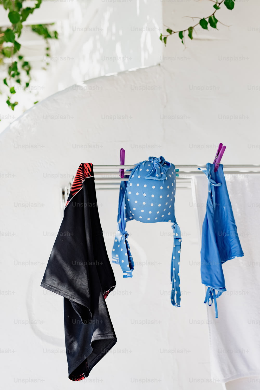 clothes hanging on a clothes line next to a white wall