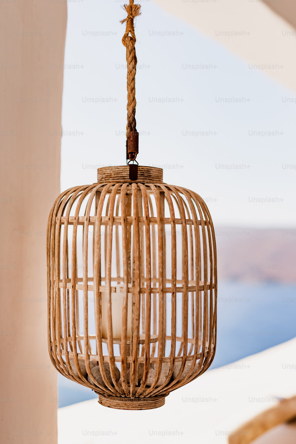 a wicker lantern hanging from a ceiling
