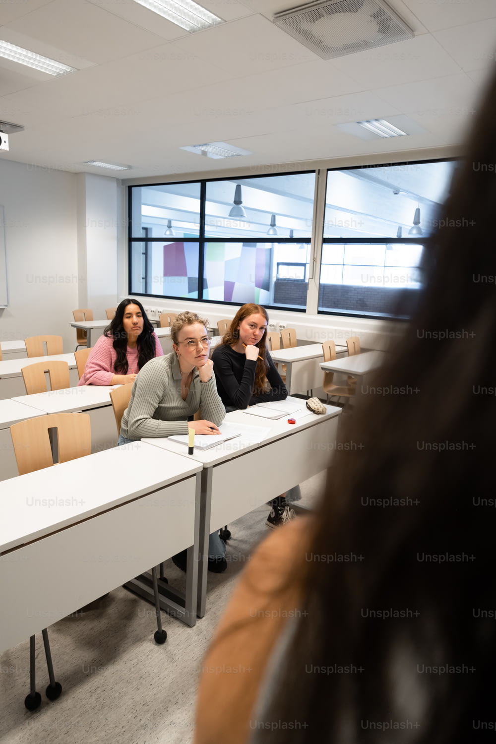 Un grupo de personas sentadas en escritorios en un aula