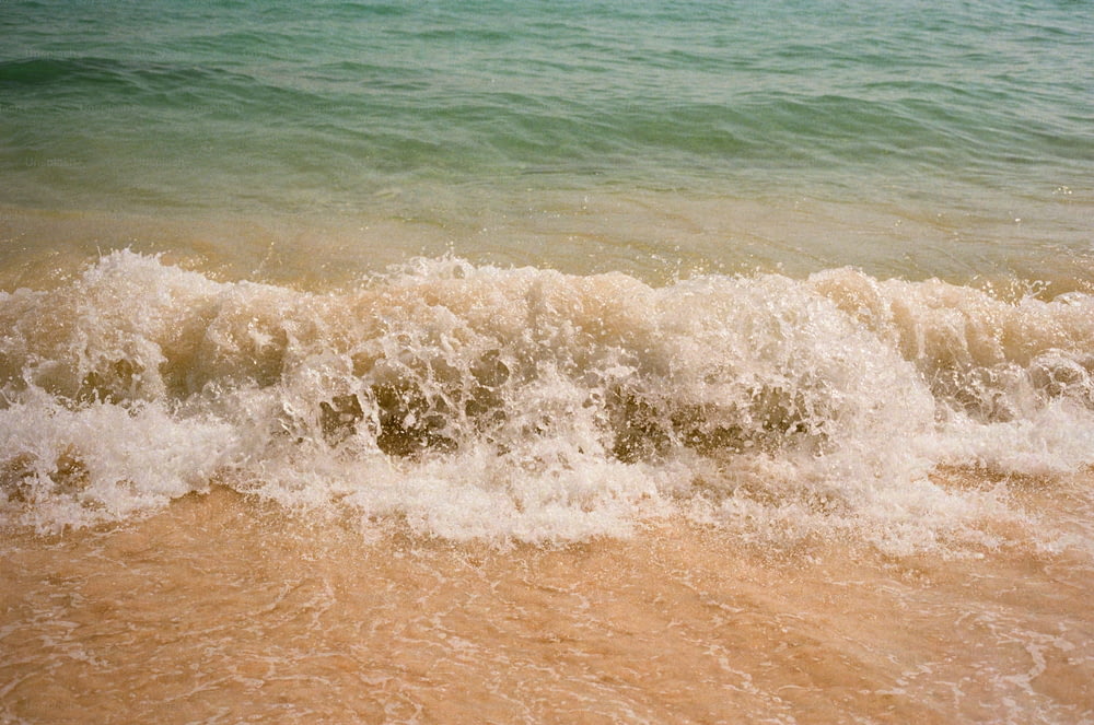 Una ola está llegando a la orilla de la playa