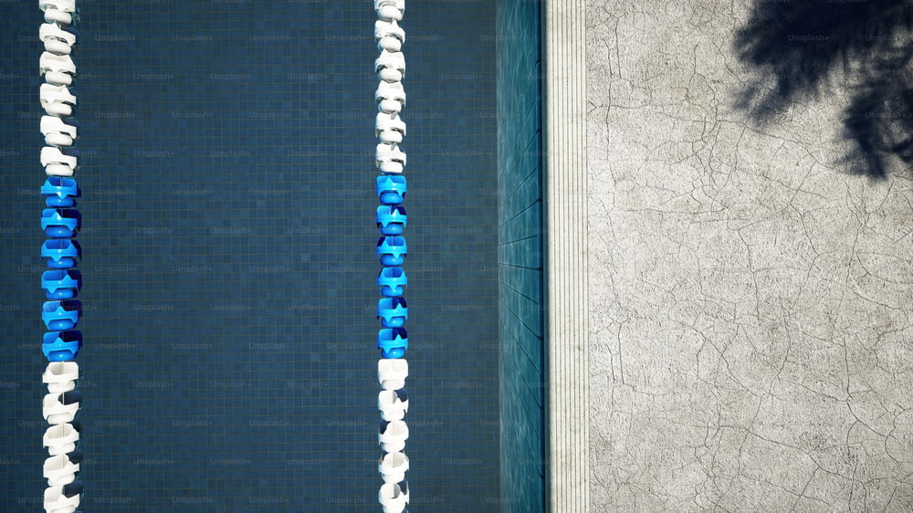an overhead view of a swimming pool with blue and white tiles