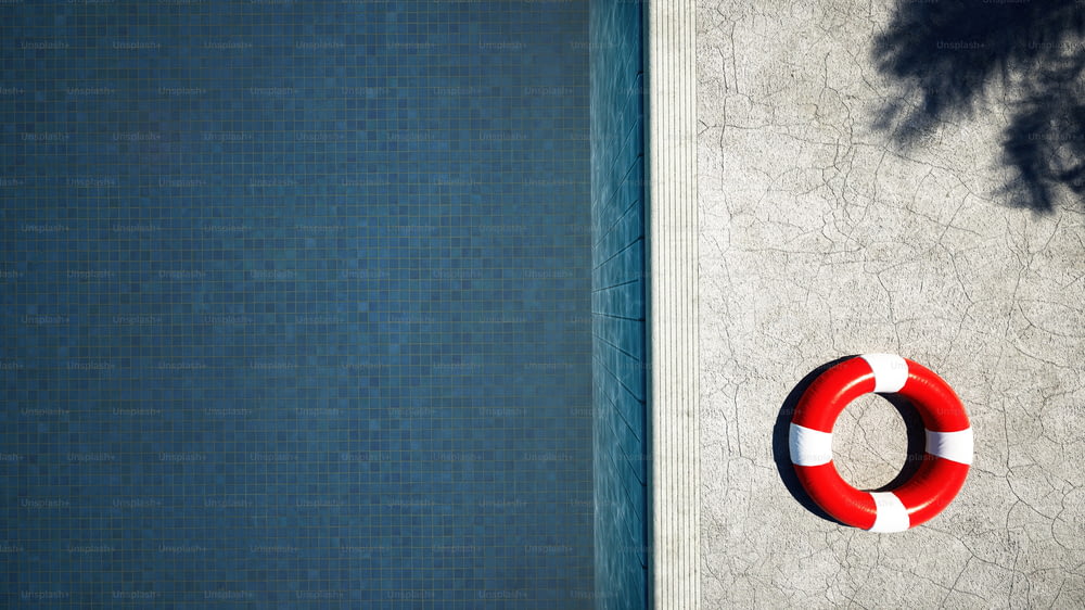 um salva-vidas vermelho e branco ao lado de uma piscina