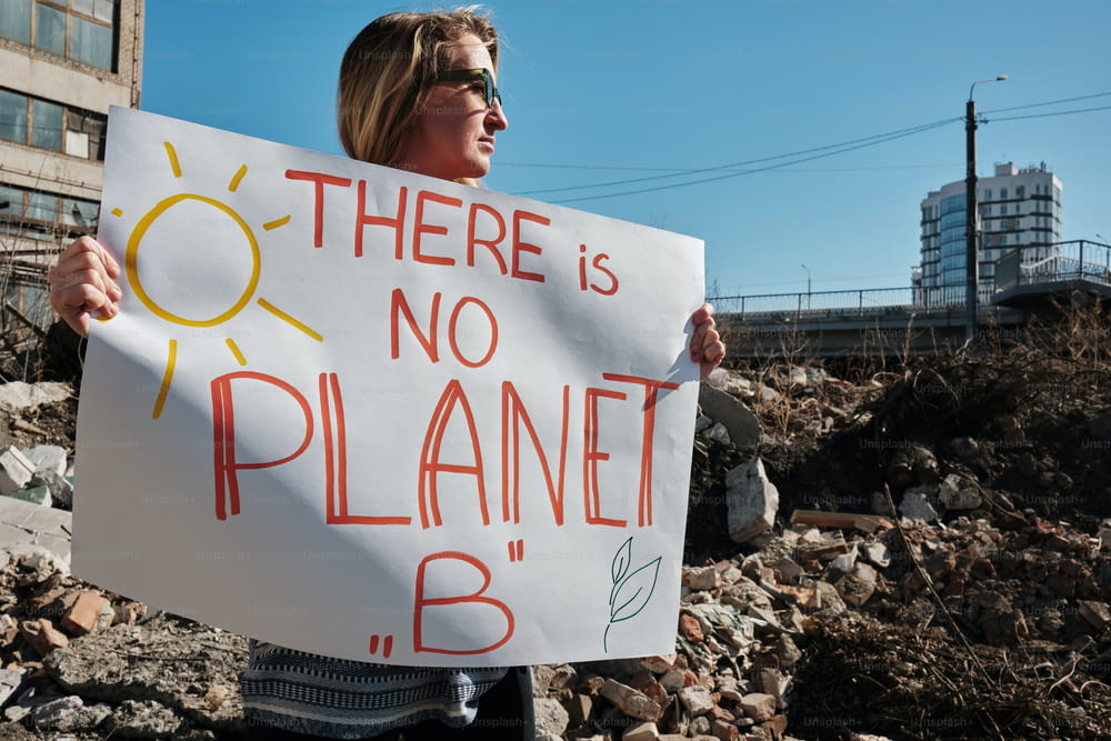 Una mujer sosteniendo un cartel que dice que no hay planeta B