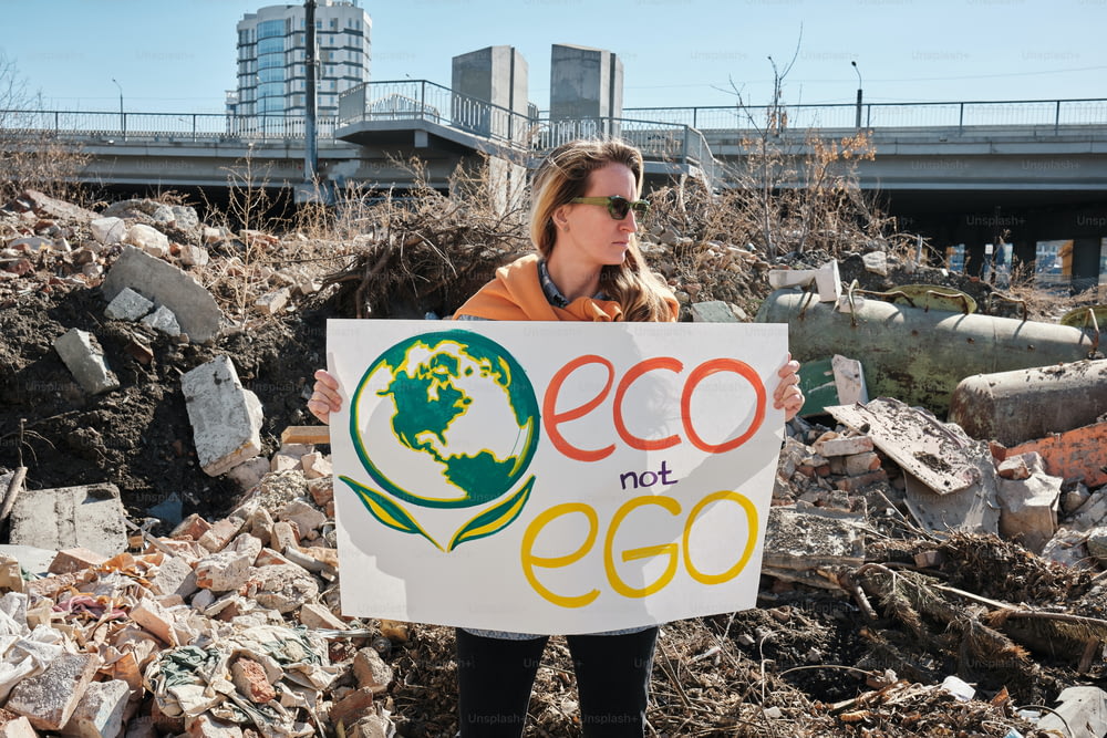 a woman holding a sign that says eco not eco