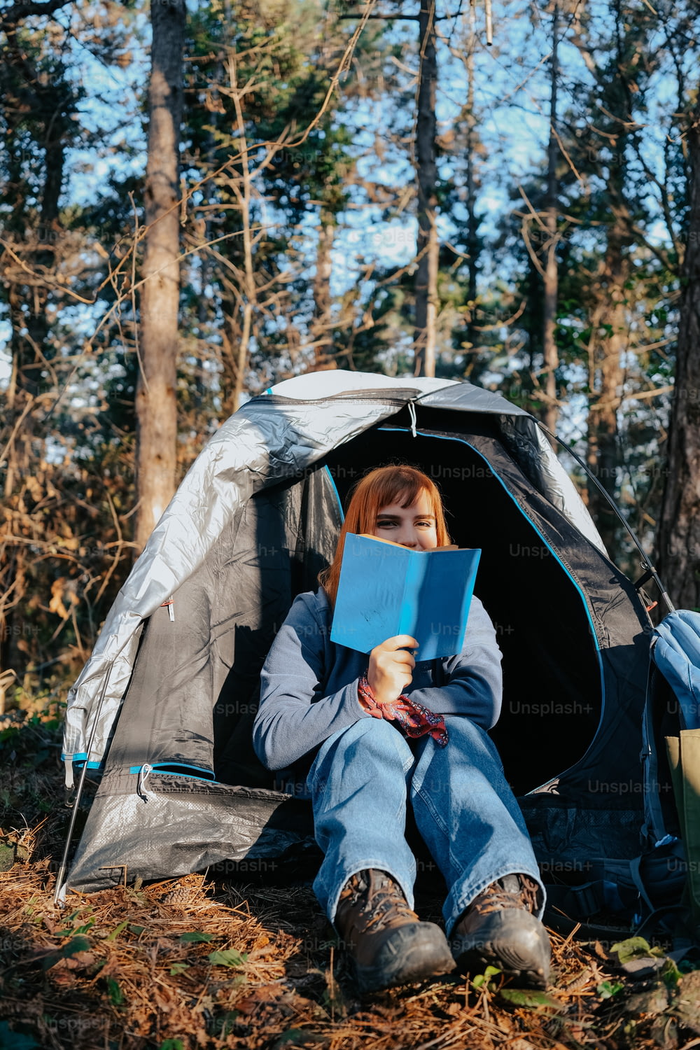 テントに座って本を読む女性