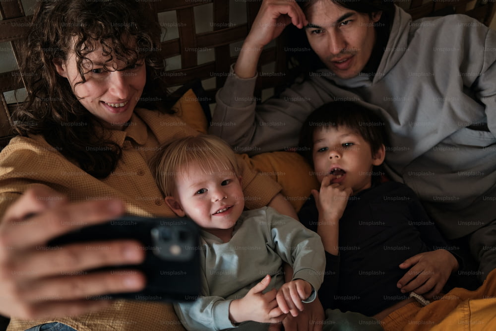 uma mulher que tira uma foto de uma família com um telefone celular