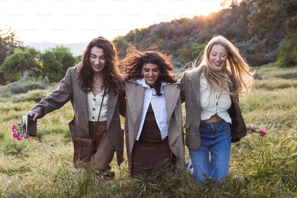 a group of three women walking through a field