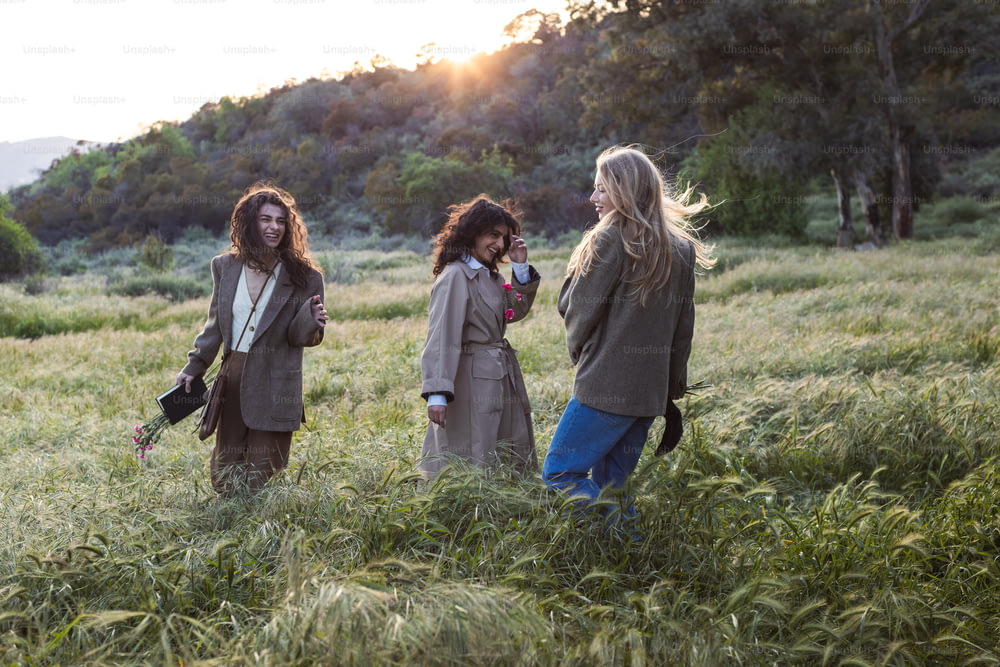 a group of women standing in a field of tall grass