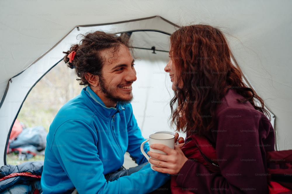 un uomo e una donna seduti in una tenda che parlano