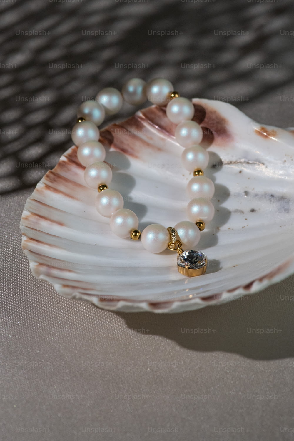 a pearl bracelet on a shell on a table