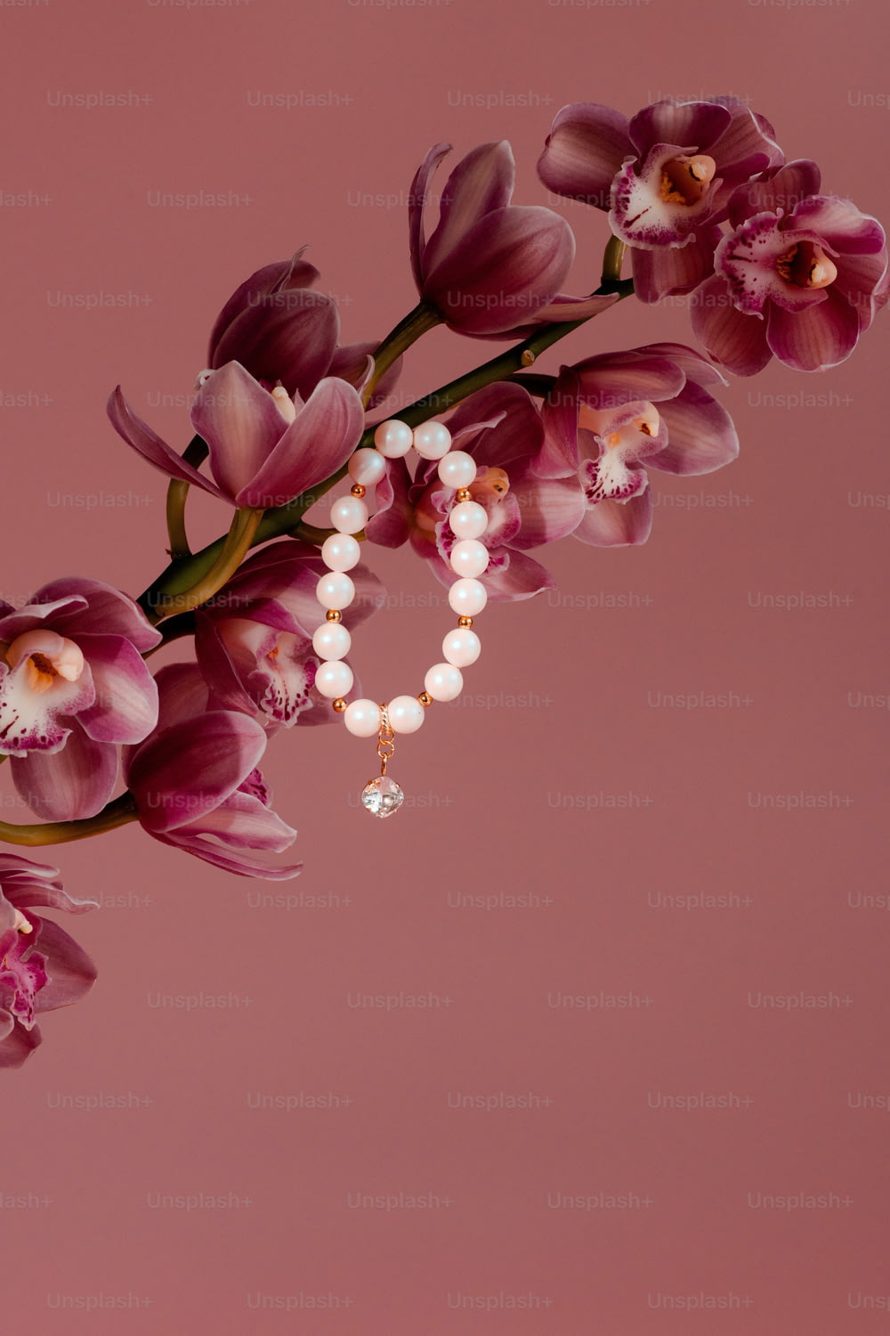 Ein Blumenstrauß mit Perlen auf rosa Hintergrund