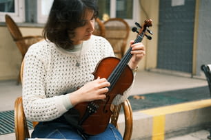 바이올린을 들고 의자에 앉아 있는 여자