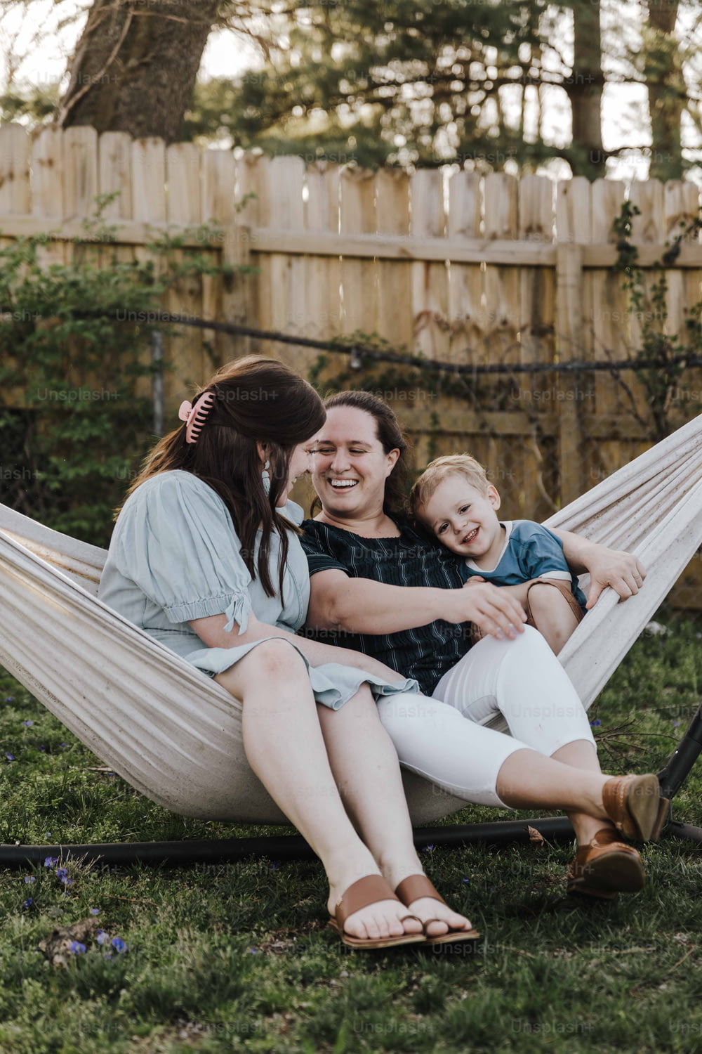 uma mulher sentada em uma rede com seus dois filhos