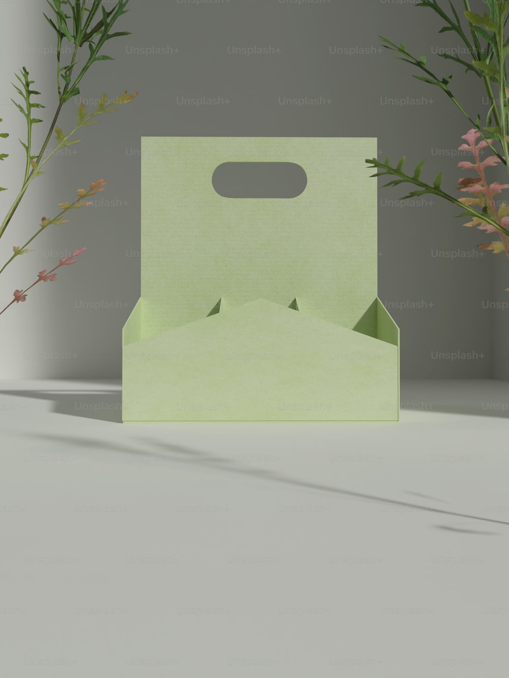 a green box sitting on top of a table next to flowers
