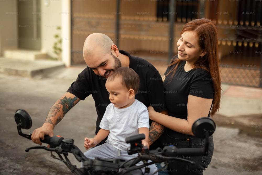 a man, woman and a baby sitting on a bike