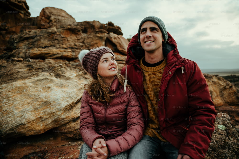 Caucasian girlfriend and boyfriend sitting on mountain smiling bonding falling in love. High quality photo