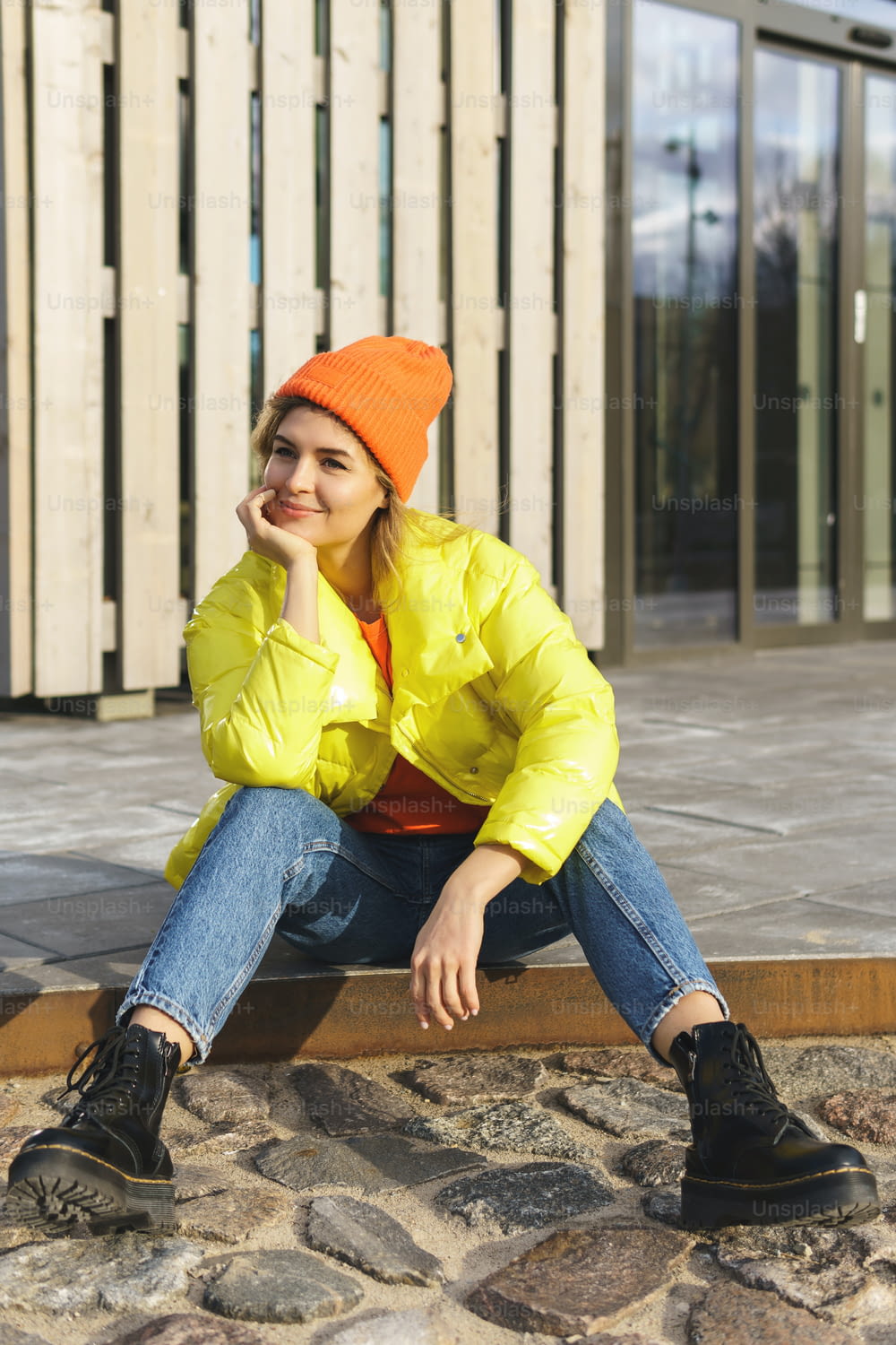 Portrait of  stylish girl wearing yellow puffer and orange knitted hat