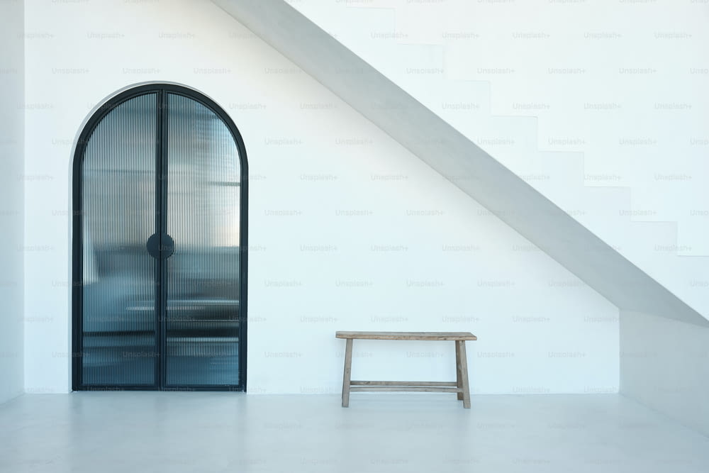 a wooden bench sitting in front of a glass door