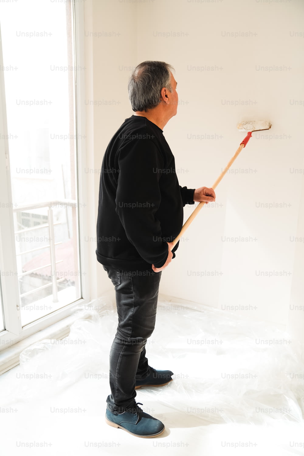 a man in a black shirt is holding a broom