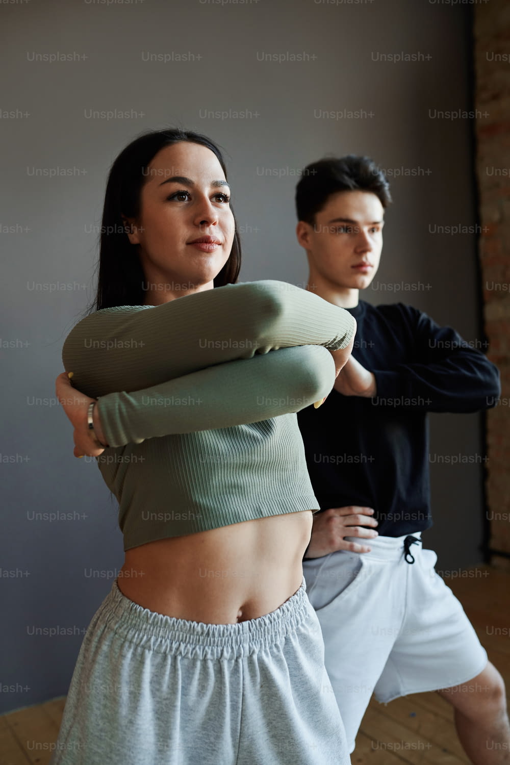 Zwei jugendliche, stilvolle Animator-Tänzer in Activewear, die im Studio Modetanz aufführen oder während der Wiederholung neue Bewegungen trainieren