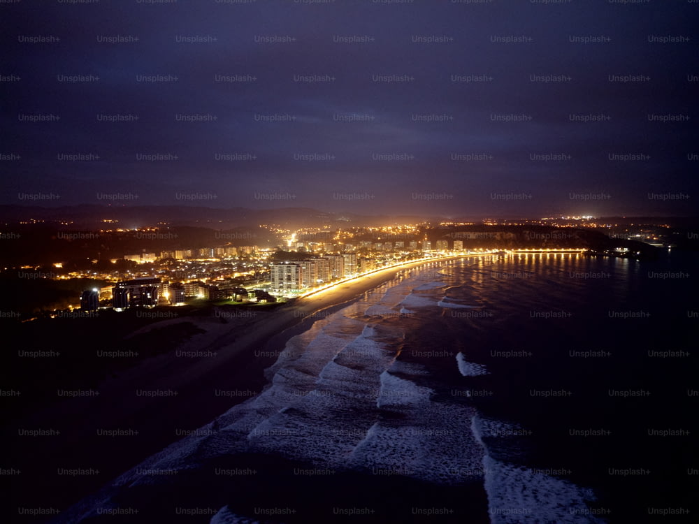 Una vista nocturna de una playa y luces de la ciudad