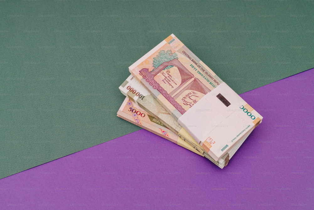 a pile of indian currency sitting on top of a purple table