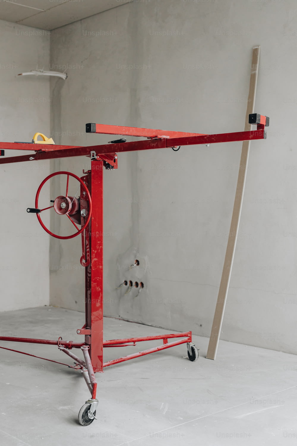 a red work stand with wheels and a handle