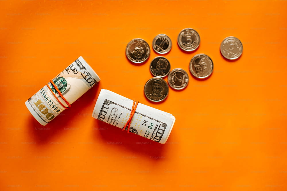 a roll of money sitting on top of an orange surface