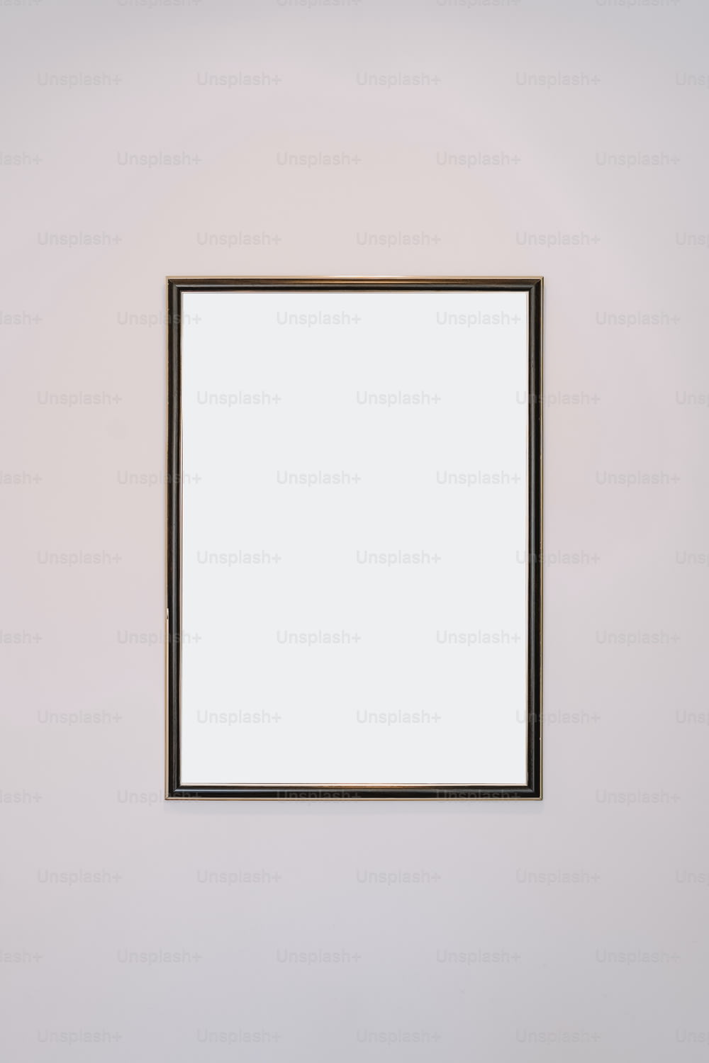a white wall with a mirror hanging on it