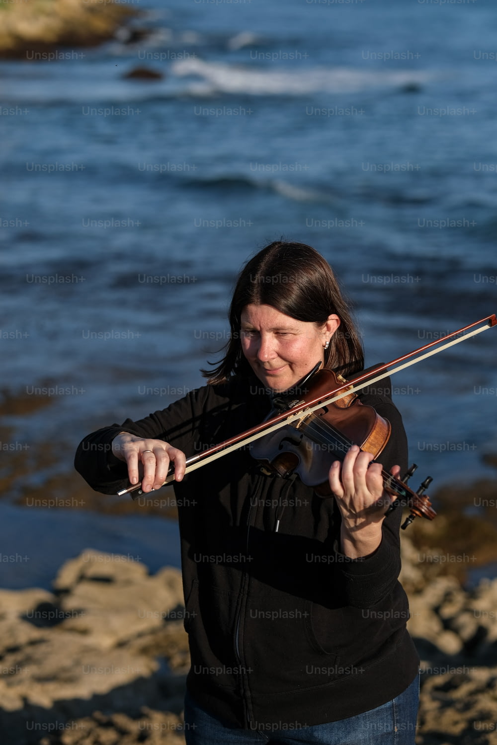 Une femme jouant du violon sur la plage