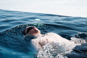 Un uomo che nuota nell'oceano con la testa sopra l'acqua