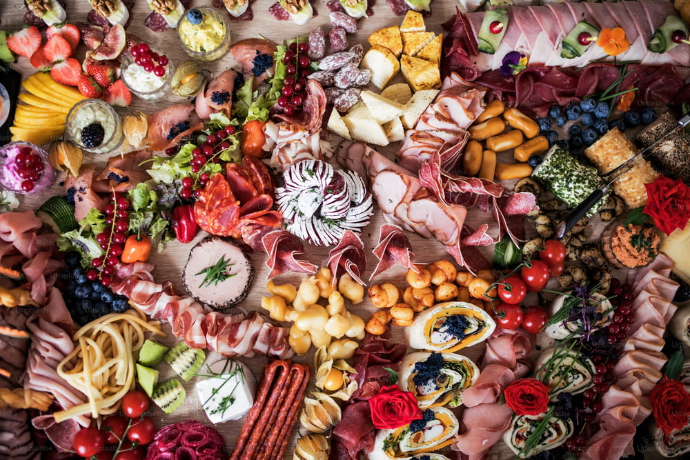 Eine Draufsicht auf verschiedene Speisen und Snacks auf einem großen Tablett auf einer Indoor-Party, ein kaltes Buffet.