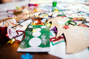 Peintures d’enfants et art et artisanat en papier de Noël à l’intérieur sur la table.