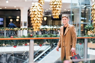 크리스마스에 쇼핑 센터를 걷고 있는 십대 소년의 초상화. 복사 공간.