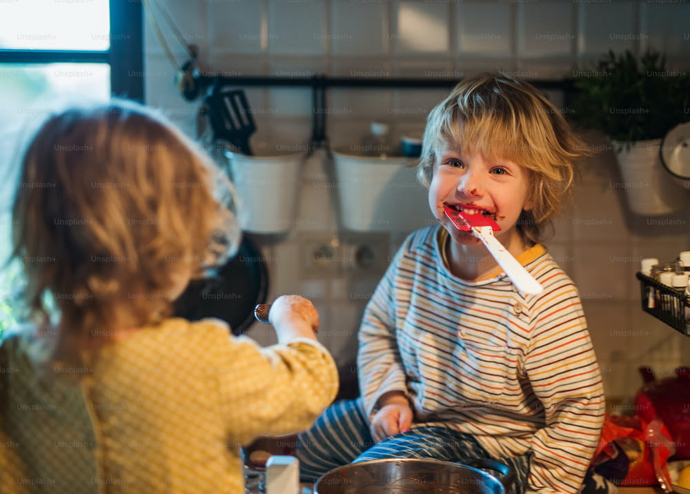 행복��한 어린 소년과 소녀는 집 부엌에서 요리를 돕는다.