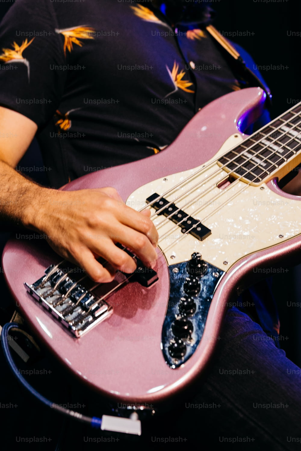 Un uomo che suona una chitarra elettrica rosa