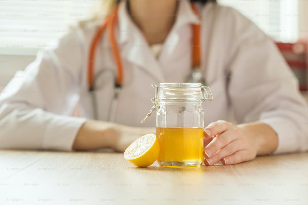 배경에 의사 여자가 있는 꿀과 레몬의 세부 사항