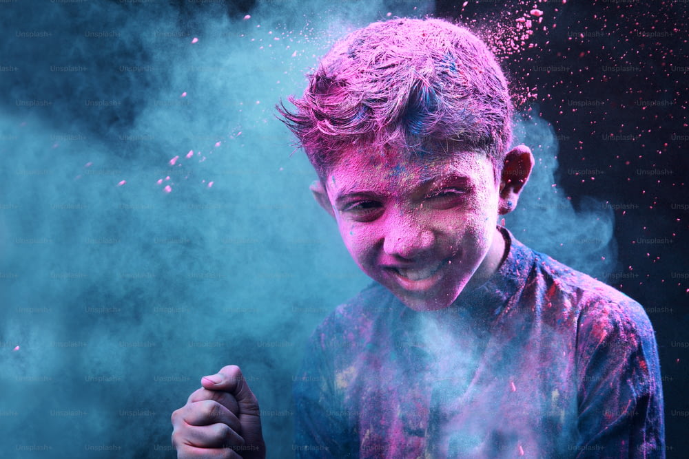 Little boy plays with colours. Concepts for Indian festival Holi
