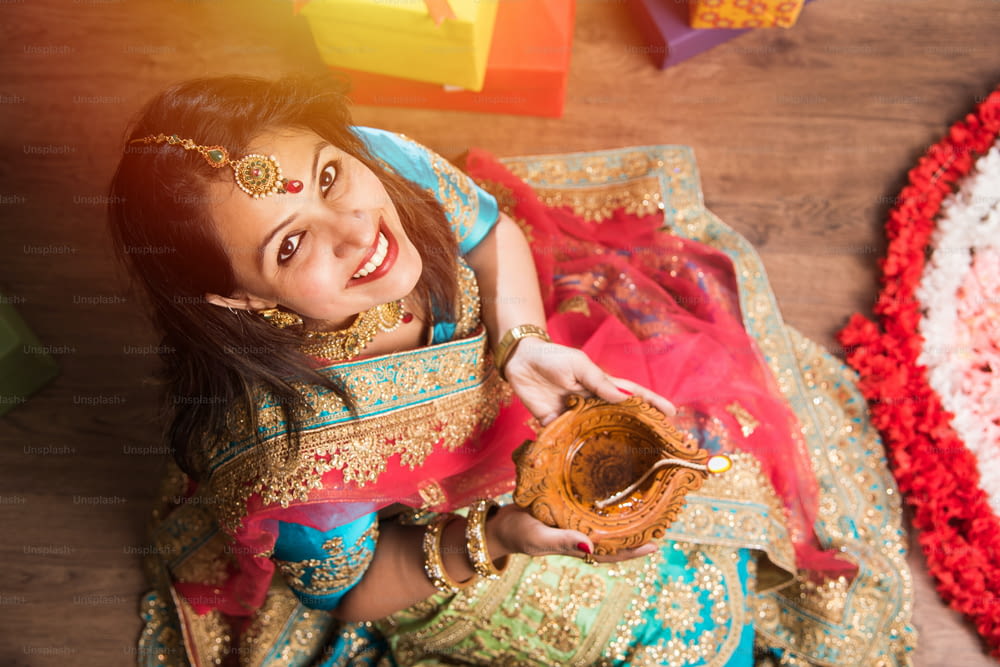 Schönes indisches Mädchen, das Diya in der Diwali-Festivalnacht hält, Draufsicht.
