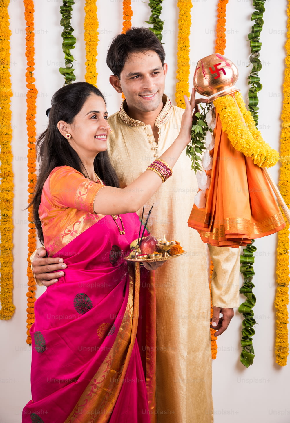 グディ・パドワ・プジャを行うスマートなインド人夫婦、アジア人カップルとプージャ・ターリ、プージャやプージャを行うインドの若いカップル、ヒンドゥー教の新年グディ・パドワ/グディ・パドワ、伝統的な服装で祈るインド人夫婦
