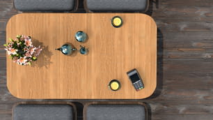an overhead view of a table with a cell phone and a vase of flowers