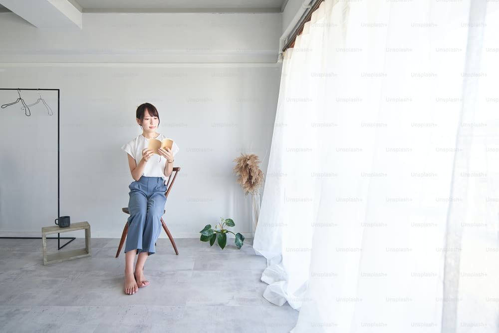 A woman reading a book in a simple bright room