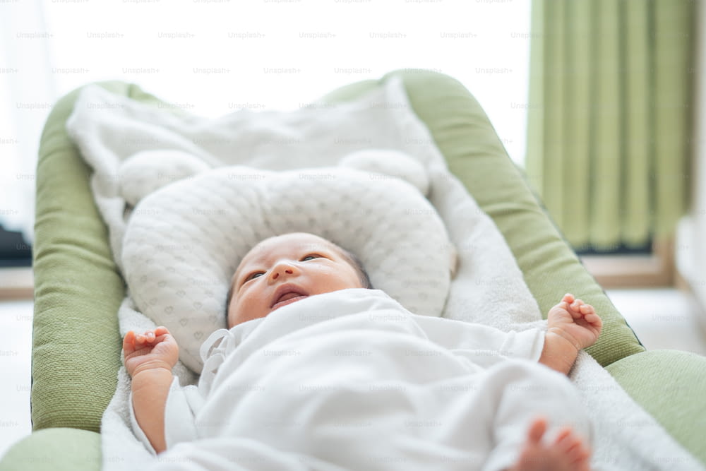 Recién nacido asiático (japonés) bebé en la cama (0 años 0 meses)