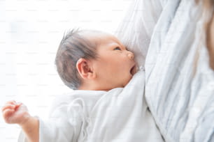Une mère portant un nouveau-né asiatique (japonais) (0 an 0 mois)