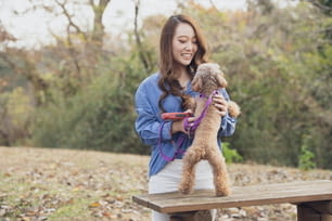 Young Asian woman walking in the park with her pet