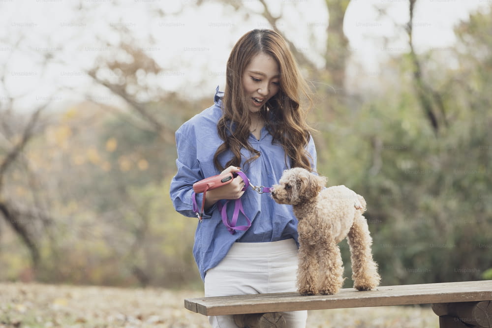Jeune femme asiatique se promenant dans le parc avec son animal de compagnie