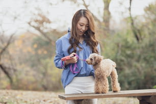 ペットと一緒に公園を歩くアジアの若い女性