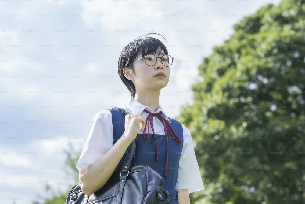 asian high school girl with glasses looking up at the sky