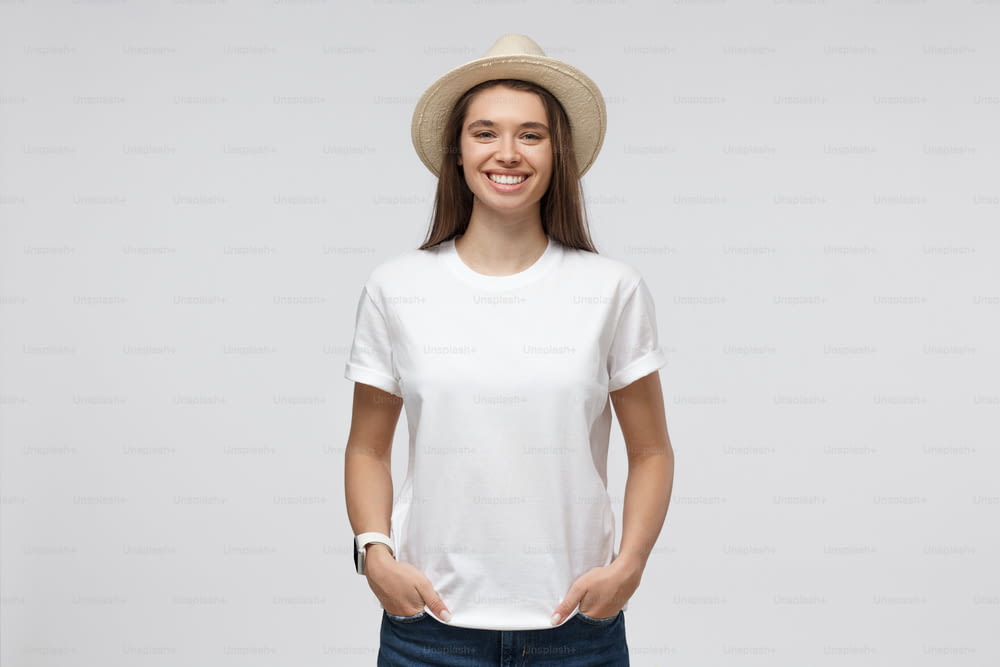 Relaxed young smiling girl in summer hat isolated on gray background