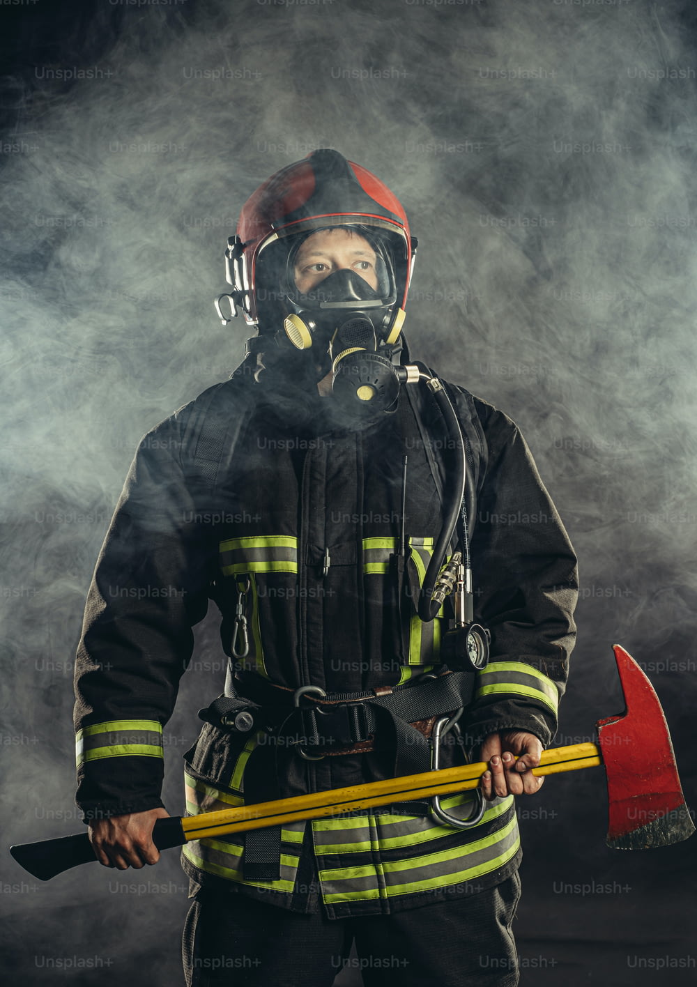 Starker selbstbewusster Feuerwehrmann, der vor Feuer rettet und schützt, Schutzhelm und Schutzanzug trägt und in der Feuerwache arbeitet